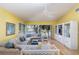 Bright living room featuring a comfortable sectional sofa, fan, and large windows at 1041 Capri Isles Blvd # 232, Venice, FL 34292