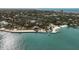 Wide aerial view of a waterfront community, showcasing the beach, a boat dock, and azure waters at 105 Pass Key Rd # 105, Sarasota, FL 34242