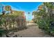 Tropical backyard with a path leading to the beach and the ocean with views of palms and lush landscaping at 105 Pass Key Rd # 105, Sarasota, FL 34242