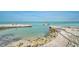 Beautiful beach view with clear water and a boat for a relaxing day at 105 Pass Key Rd # 105, Sarasota, FL 34242