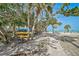 Picturesque beach access featuring shade trees, stacked colorful kayaks, and a brick pathway at 105 Pass Key Rd # 105, Sarasota, FL 34242