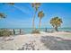Picturesque beach scene featuring a boat dock and tables facing the ocean under clear blue sky at 105 Pass Key Rd # 105, Sarasota, FL 34242