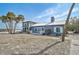 Charming blue coastal home with metal roof and white trim near the beach, surrounded by palm trees at 105 Pass Key Rd # 105, Sarasota, FL 34242