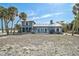 Charming blue coastal home with metal roof and white trim near the beach, surrounded by palm trees at 105 Pass Key Rd # 105, Sarasota, FL 34242