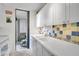 Well-lit kitchen with white cabinetry, colorful tile backsplash, and modern appliances at 105 Pass Key Rd # 105, Sarasota, FL 34242