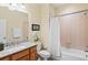 A cozy bathroom featuring granite countertops, wood cabinetry, and a shower and tub combo at 1123 Riverscape St # D, Bradenton, FL 34208