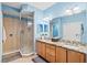 Bright bathroom featuring double sinks, a spacious shower, granite countertops, and wood cabinetry at 1123 Riverscape St # D, Bradenton, FL 34208