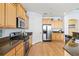 Well-equipped kitchen with wood cabinetry, granite countertops, and stainless steel appliances for modern convenience at 1123 Riverscape St # D, Bradenton, FL 34208