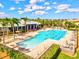 Aerial view of large community pool, clubhouse, lounge chairs, and palm trees under a sunny sky at 1123 Riverscape St # D, Bradenton, FL 34208