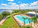 Aerial view of the community pool with lush landscaping, lounge chairs, and an adjacent walking path at 1123 Riverscape St # D, Bradenton, FL 34208