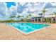 Large community pool with multiple swimming lanes, lounge chairs, clubhouse, and tropical landscaping at 1123 Riverscape St # D, Bradenton, FL 34208