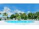 Community pool surrounded by lush tropical landscaping and ample seating at 11606 Apple Tree Cir, Bradenton, FL 34211