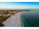Stunning aerial view showcasing the coastline, featuring a beautiful white sand beach meeting clear turquoise water, and city skyline at 1163 Coquille St # 207, Sarasota, FL 34242