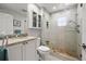 Modern bathroom showcasing a granite vanity, sleek fixtures, and a glass-enclosed shower with pebble base at 1163 Coquille St # 207, Sarasota, FL 34242