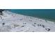 Scenic aerial view of a sprawling beach with clear blue waters and scattered beachgoers at 1163 Coquille St # 207, Sarasota, FL 34242