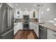 Modern kitchen featuring white cabinets, granite countertops, stainless steel appliances, and stylish backsplash, a chef's delight at 1163 Coquille St # 207, Sarasota, FL 34242