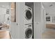Convenient laundry area with stacked washer and dryer inside a hallway of the home at 1163 Coquille St # 207, Sarasota, FL 34242