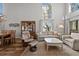 Bright living room with high ceilings, large windows, and comfortable seating arrangement at 1163 Coquille St # 207, Sarasota, FL 34242