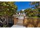 Inviting community pool area with lush tropical landscaping and a wooden access gate at 1163 Coquille St # 207, Sarasota, FL 34242