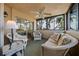 Cozy screened porch featuring comfortable seating, a ceiling fan, and beautiful outdoor views at 1163 Coquille St # 207, Sarasota, FL 34242