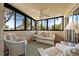 Relaxing screened porch with wicker furniture, a ceiling fan, and serene views of tropical foliage at 1163 Coquille St # 207, Sarasota, FL 34242