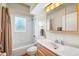 Cozy bathroom featuring a white vanity, tub with shower, and a window at 12103 Shadow Run Blvd, Riverview, FL 33569