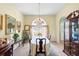 Formal dining room with elegant chandelier, arched window, and classic furniture at 12103 Shadow Run Blvd, Riverview, FL 33569