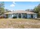 Inviting light blue home with arched windows and a well-maintained lawn on a sunny day at 12103 Shadow Run Blvd, Riverview, FL 33569