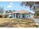 Beautiful one-story home with a light blue exterior, arched windows, and a green lawn at 12103 Shadow Run Blvd, Riverview, FL 33569