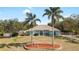 Charming home featuring palm trees, arched windows, and a well-manicured lawn, enhancing curb appeal at 12103 Shadow Run Blvd, Riverview, FL 33569