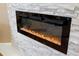 Modern electric fireplace with crystals set in a stone accent wall for a cozy ambiance at 12103 Shadow Run Blvd, Riverview, FL 33569