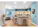 Open kitchen with light wood cabinets, large island, granite countertops, and blue accent walls at 12103 Shadow Run Blvd, Riverview, FL 33569