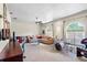 Inviting living room featuring a leather couch, drum set, natural light from large arched windows, and a ceiling fan at 12103 Shadow Run Blvd, Riverview, FL 33569