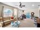 Comfortable living room featuring a large sectional sofa, ceiling fan, arched windows, and music instruments at 12103 Shadow Run Blvd, Riverview, FL 33569