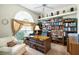 Cozy office with built-in bookshelves, a large window with curtains, and a ceiling fan at 12103 Shadow Run Blvd, Riverview, FL 33569