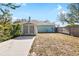 Backyard view with a shed and concrete driveway, surrounded by well-maintained wooden fences at 12103 Shadow Run Blvd, Riverview, FL 33569
