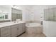 Luxurious bathroom featuring double vanity, soaking tub, and a glass enclosed shower at 12557 Galapagos Ct, Venice, FL 34293