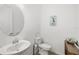 Clean half bath with a pedestal sink, toilet, and tasteful coastal décor at 12557 Galapagos Ct, Venice, FL 34293