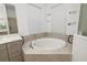 Soaking tub with tile surround and white walls, allowing for relaxation at 12557 Galapagos Ct, Venice, FL 34293