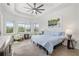 Bright primary bedroom with large windows, tray ceiling, and comfortable seating area at 12557 Galapagos Ct, Venice, FL 34293
