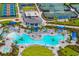 Aerial view of a luxurious community pool with palm trees, lounge chairs, and a splash pad at 12557 Galapagos Ct, Venice, FL 34293