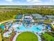 Aerial view of a community pool and tennis courts, surrounded by lush greenery, offering resort-style living at 12557 Galapagos Ct, Venice, FL 34293