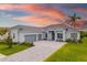 Charming single-story home featuring a tile roof, a three-car garage, and a well-manicured lawn at 12557 Galapagos Ct, Venice, FL 34293