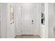 Bright and inviting foyer with a white front door, sidelights, and coastal-themed decor at 12557 Galapagos Ct, Venice, FL 34293