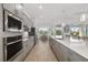 Open-concept kitchen with stainless steel appliances and barstool seating with pendant lighting at 12557 Galapagos Ct, Venice, FL 34293