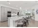 Modern kitchen features an island with bar stool seating and pendant lighting at 12557 Galapagos Ct, Venice, FL 34293