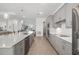 Modern open-concept kitchen with grey cabinets, stainless steel appliances, and a large island at 12557 Galapagos Ct, Venice, FL 34293