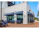 Exterior patio with brick flooring and blue striped awnings and plenty of outdoor seating at 12557 Galapagos Ct, Venice, FL 34293