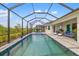 Full view of screened pool, spa, patio, and outdoor seating, surrounded by beautiful landscaping at 12557 Galapagos Ct, Venice, FL 34293