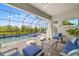 Relaxing screened-in patio with TV, comfortable seating, and view of the serene pool area at 12557 Galapagos Ct, Venice, FL 34293